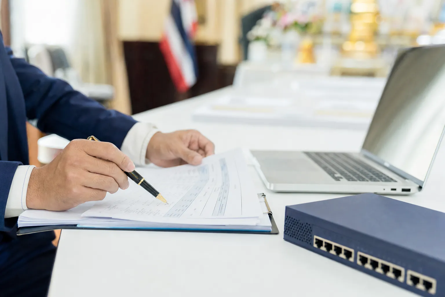 Procurement documents and a laptop on a meeting table